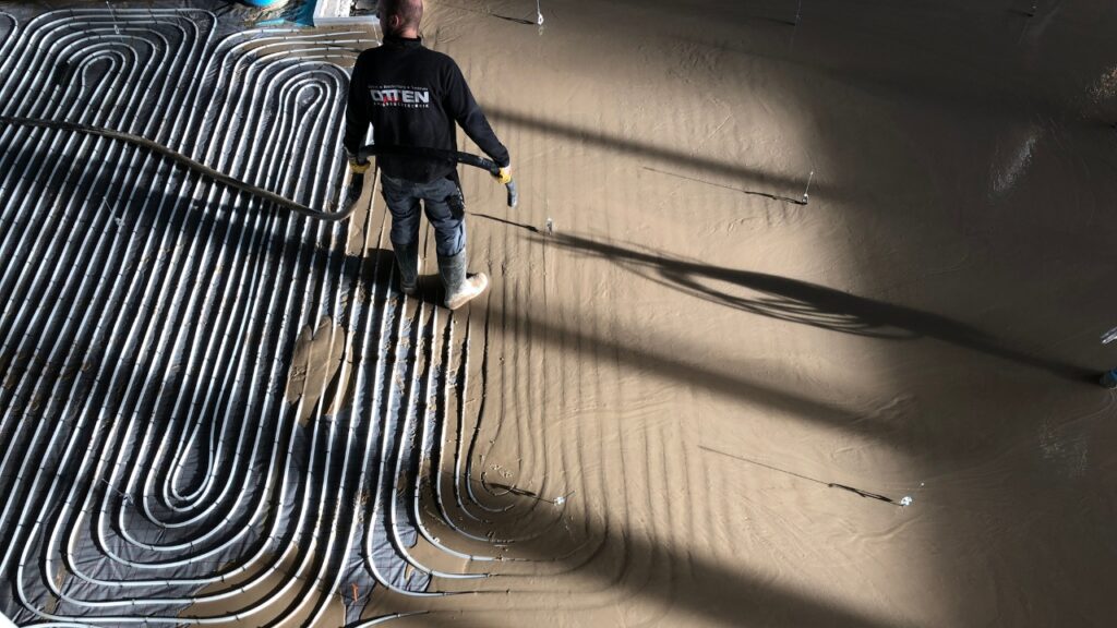 Eingießen und Verteilen des Estrichs über dem Heizsystem durch Otten Fußbodentechnik GmbH & Co. KG